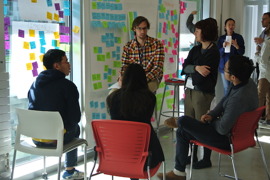 people collaborating around ideas on post-it notes